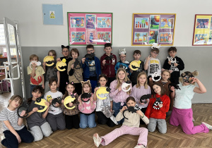 Uczniowie z klasy 3d w kocich przebraniach prezentujący wykonane prace plastyczne