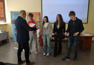 Uczniowie otrzymują dyplomy za udział w grze miejskiej Kocham Windy.