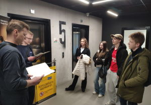 Uczniowie słuchają informacji nt. zasad funkcjonowania firmy produkującej windy osobowe i towarowe, schody ruchome, chodniki ruchome oraz drzwi automatyczne.