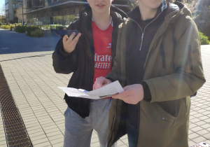 Uczniowie szukają wyznaczonych miejsc i nawiązują kontakt telefoniczny z osobami czekającymi na wyznaczonych miejscach.