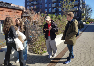 Uczniowie szukają wyznaczonych miejsc i nawiązują kontakt telefoniczny z osobami czekającymi na wyznaczonych miejscach.