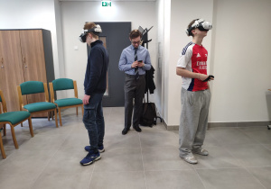 Uczniowie z założonymi goglami VR, w których odbyli wirtualny spacer po dźwigu osobowym.