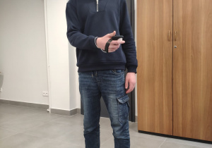 Uczeń z założonymi goglami VR, w których odbyli wirtualny spacer po dźwigu osobowym.