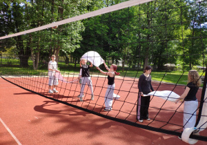 Uczniowie grają w siatkówkę za pomocą ręczników