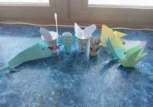 7.Siedem zwierząt wykonanych albo techniką origami albo z papierowych kubków i rolek. Wszystkie ustawione są na niebieskim parapecie.