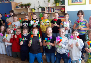 Na zdjęciu znajdują się uczniowie klasy 3a, którzy prezentują kwiaty zrobione z papieru i bibuły.