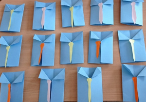 Zdjęcie przedstawia galerię prac - laurki w kształcie koszuli z krawatem, zrobione z papieru przez klasę 3a z okazji Dnia Ojca.