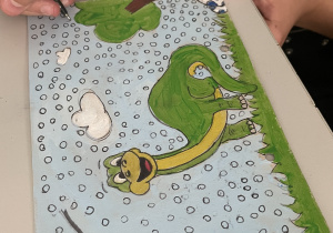 Zielono-żółty dinozaur na kartce urodzinowej dla Blanki.