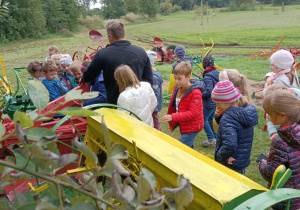 Na zdjęciu dzieci z klasy 2a oglądają dawne maszyny rolnicze.