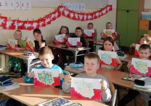 Zdjęcie przedstawia uczniów kl. Ib prezentujących prace plastyczne wykonane z okazji Święta Niepodległości.