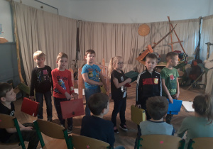Zdjęcie przedstawia uczniów klasy 1a podczas warsztatów teatralnych, uczniowie realizują zadanie zlecone przez prowadzących zajęcia.