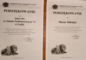 Na zdjęciu widoczne są dwie karty z podziękowaniami za przeprowadzenie zbiórki podarunków dla podopiecznych schroniska dla zwierząt w Łodzi. Jedna skierowana jest do Marty, natomiast druga do uczniów klasy 2a.