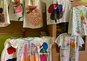 Koszulki przedstawiające modele różnych układów narządow człowieka wykonane przez uczniów z klas siodmych