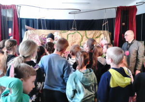 Zdjęcie przedstawia uczniów klasy 3a podczas warsztatów teatralnych wraz z prowadzącymi zajęcia; uczniowie realizują zlecone zadanie.