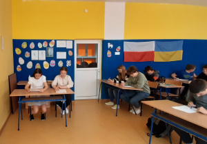 Wolontariusze piszący test wiedzy o Polskim Czerwonym Krzyżu.