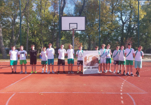 Uczniowie rozgrywający mecz koszykówki na boisku szkolnym.