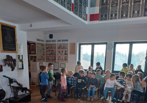 Zdjęcie przedstawia uczniów klasy 1b przygotowujących się do prelekcji na temat eksponatów zgromadzonych w Muzeum Armii Krajowej Okręgu Wileńskiego