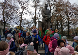 Uczniowie klas IIIa i IIIb stoją przed Pomnikiem Józefa Piłsudskiego.