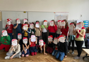 Zdjęcie przedstawia uczniów klasy 3b zasłaniających twarze swoimi pracami