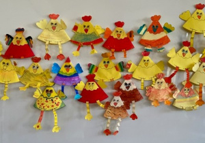Zdjęcie przedstawia kurczaki wykonane z kolorowego papieru przez uczniów klasy 3b.