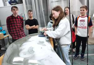 Uczniowie kl. 7b podczas warsztatów z lakiernictwa polerują elementy samochodu