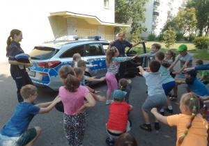 Dzieci wykonują rozgrzewkę prowadzoną przez Panie policjantki.