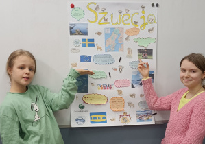 Uczennice kl. 3a prezentują plakat z ciekawostkami o Szwecji.