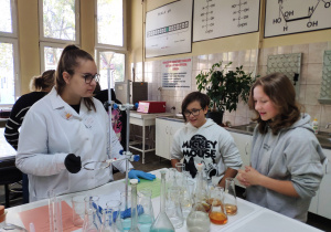 Dziewczynki podczas badań nad kwasowością napojów w pracowni kontroli jakości i bezpieczeństwa żywności