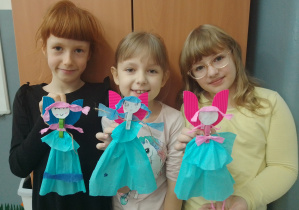 Dziewczynki prezentują ozdoby świąteczne - aniołki wykonane z papieru, bibuły i spinacza do bielizny