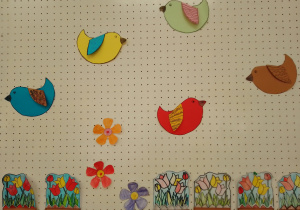 Prace przedstawiające kwiaty wiosenne oraz kolorowe ptaszki, wykonane przez uczniów klasy 2a
