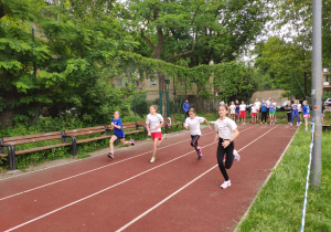 Dziewczynki biegną na dystansie 60 m, drużyna SP 71 na torze nr 2.
