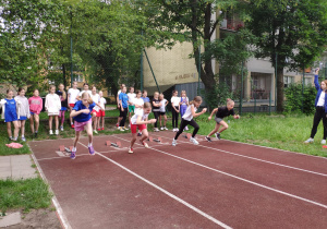 Dziewczynki biegną na dystansie 60 m, drużyna SP 71 na torze nr 2.