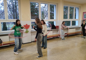 Uczniowie podczas zabaw z obręczami hula – hop