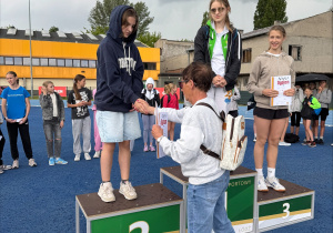 Dekoracja z uściskiem ręki naszej zawodniczki, która stanęła na 2 stopniu podium.