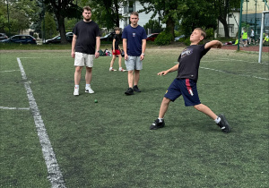 Zawodnik w ciemnym stroju podczas rzutu piłeczką palantową