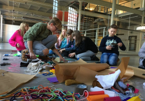 Uczniowie wykonują prace z kolorowych materiałów.