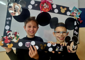 Dzieci pozujące do zdjęcia, trzymające ramkę