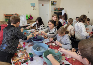 Uczniowie klas czwartych w trakcie dekorowania bombek