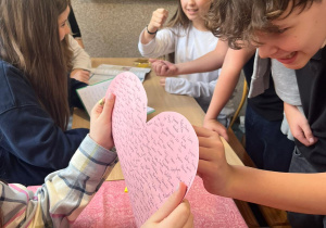Uczeń przebijający papierowe serce w trakcie jednej z zabaw.