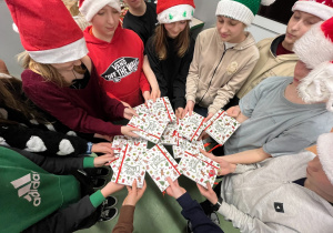 Uczniowie klasy piątej trzymający świąteczne kartki.