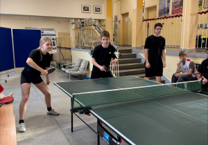 Reprezentanci klas 8 w trakcie gry w tenisa stołowego.