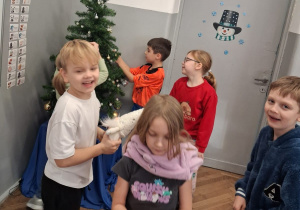 Uczniowie klasy 1c dekorują choinkę klasową