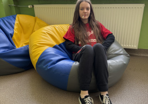 Uczennica klasy 6 odpoczywa na siedzisku.